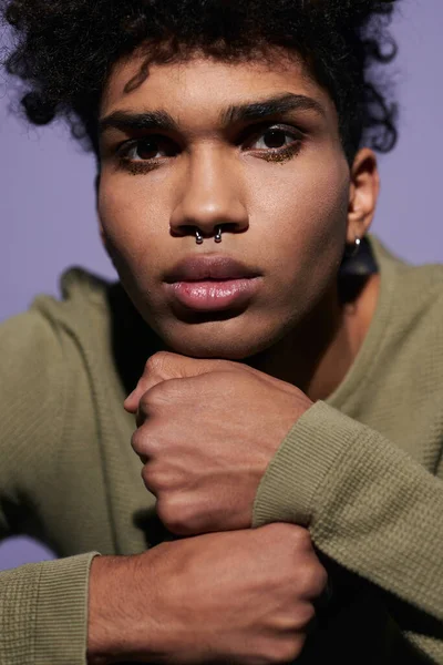 Close up portrait of young afroamerican man face on arms. Sexy transgender male with pirsing in nose — Stock Photo, Image