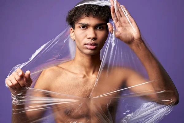 Fiatal transznemű férfi, műanyag zacskóval a meztelen, izmos testén. Transznemű férfi lélegzik — Stock Fotó