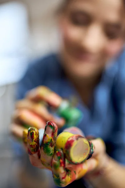 Foto dari seorang seniman perempuan yang sedang memegang cat minyak akrilik berwarna-warni dalam toples — Stok Foto