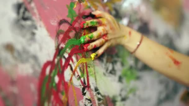 Libera tu creatividad. Primer plano de la mano de una mujer joven aplicando pintura sobre lienzo con los dedos, creando una pintura en el estudio de casa — Vídeo de stock