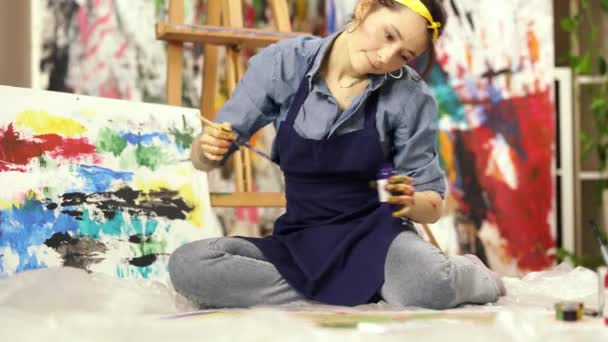Ottimo metodo per ridurre lo stress. Ispirato giovane donna creando pittura astratta mentre seduto sul pavimento a casa laboratorio di studio — Video Stock