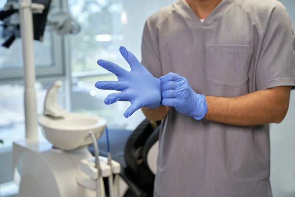 Diş kliniğinde tek kullanımlık eldiven kullanan bir tıp çalışanı. — Stok fotoğraf