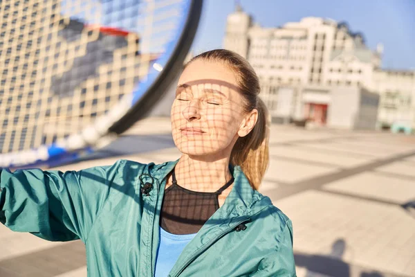 Portret atrakcyjnej sportowczyni w średnim wieku trzymającej rakietkę tenisową, stojącej z zamkniętymi oczami, gotowej do porannego treningu na świeżym powietrzu — Zdjęcie stockowe