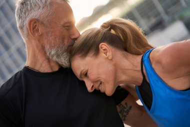 Sevecen orta yaşlı bir çiftin portresi, spor giyimli bir erkek ve kadın bir yaz günü şehirde sabah sporu yapıyorlar.