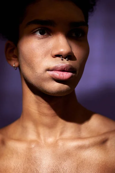 Közelkép függőleges portré egy fiatal férfiról, izmos nyakkal, lila háttérrel. Spanyol modell — Stock Fotó