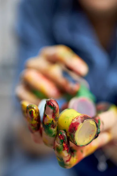 Foto jarak dekat tangan wanita memegang cat minyak akrilik berwarna-warni dalam toples — Stok Foto