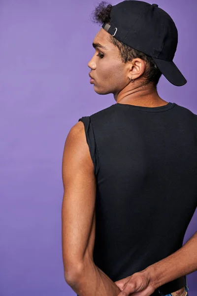 Retrato de joven morena vista trasera. Hombre guapo con camiseta negra, gorra. Modelo transgénero —  Fotos de Stock