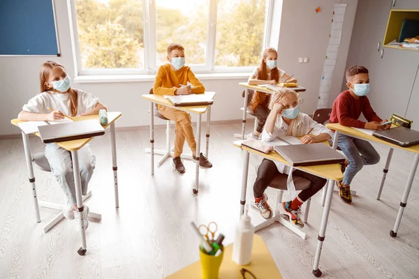 Niños de la escuela con cuadernos sentados juntos en el aula — Foto de Stock
