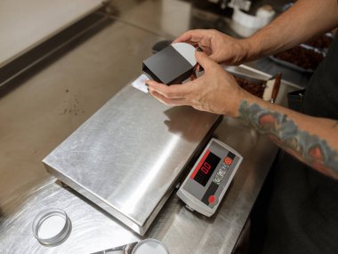 Erkek elleri, metal kahve kavanozunu siyah kutuya koyuyor.