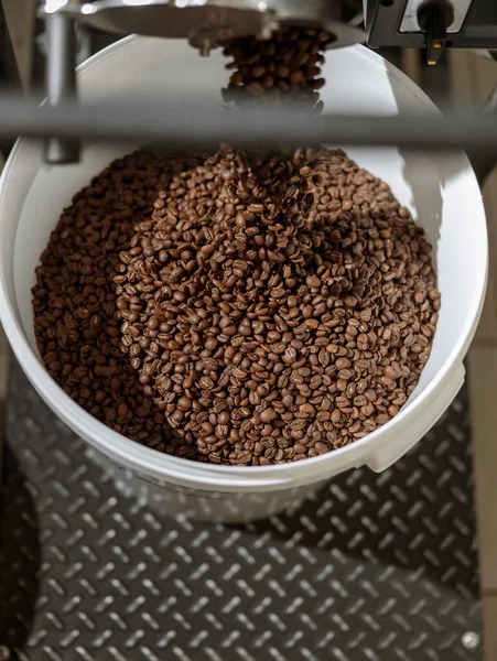 Plastikeimer mit Kaffeebohnen unter Bohnen-Auslöseschacht — Stockfoto