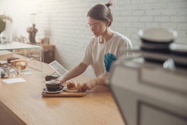 Kahve ve çörek hazırlayan hoş bir bayan.