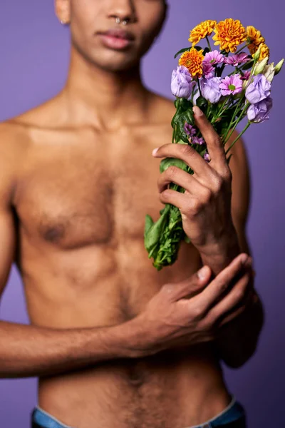 Close-up portrait of nude torso of boy with flowers in hand. Sensual latino young man posing — Stock Photo, Image