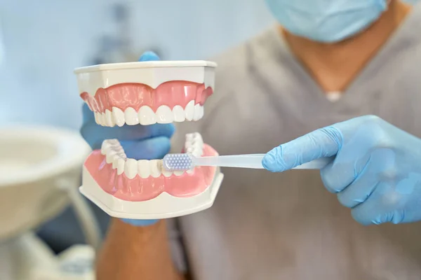 Diş hekimi, diş fırçalama kurallarını anlatıyor.