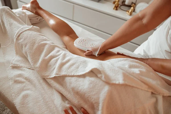 Young woman having leg massage in spa salon