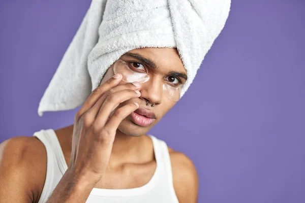 Primer plano retrato de joven afroamericano hombre en toalla uso ojo anti-arrugas parches — Foto de Stock