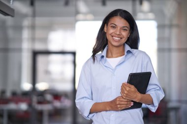 Gülümseyen kadın çalışan ve elinde elektronik tablet tutan.