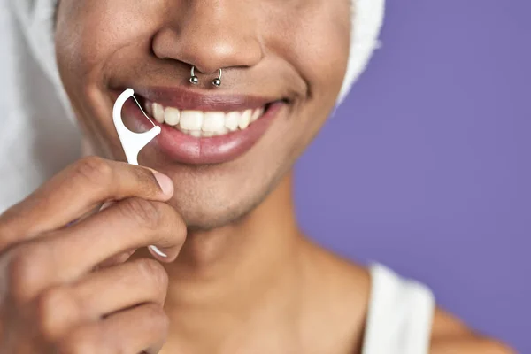 Primer plano hombre transgénero con hilo dental sonriendo sobre fondo púrpura. Transgénero afroamericano — Foto de Stock