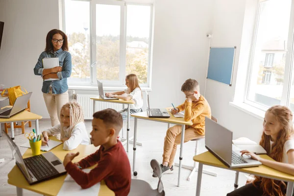 Glad elev skriver under en lektion i skolan — Stockfoto