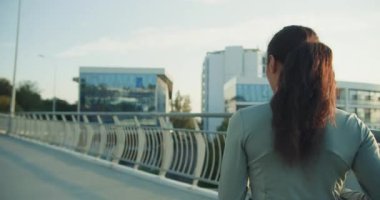 Formda bir kadın şehir ortamında koşuyor, sağlık, spor ve modern yaşam tarzını güzel bir şekilde gösteriyor.