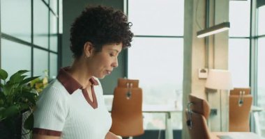 Dizin belgelerini dikkatle inceleyen kadın, sarı dosya kağıtlarını dikkatle inceleyen siyah kadın.