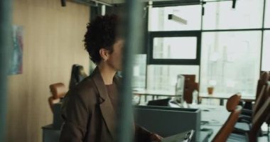 Pencerenin yanında tabletle duran siyah kadın, şehir manzarası, arka ışıklandırma camı, inceleme raporları, tıklama ekranı, veri analizi, sakinlik