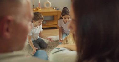 Aileler çocukları Golden Retriever ile oturma odasında oynarken izliyor. Sıcak gülümsemeler, yumuşak halı, hafta sonu havası, nazik.