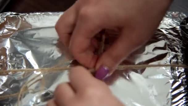 女性の手は、箔に包まれた箱の上にツインの弓を結ぶ。HD — ストック動画
