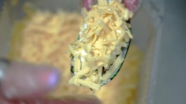 Eldivenli restoran şefi kabuklu midyeye peynir serer.