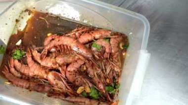 Soya soslu karides, sarımsak ve maydanoz. Şef karidesleri marine ediyor. HD
