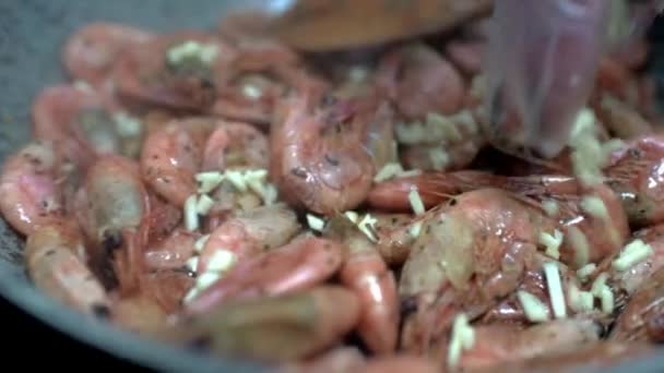 Udang digoreng dalam panci. Masak taburan kerang dengan bawang putih cincang. HD — Stok Video