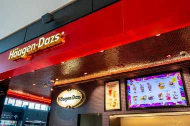 Murcia, İspanya - 31 Temmuz 2021: bir İspanyol alışveriş merkezindeki Haagen-Dazs dondurma dükkanının dışı. Duvarda satılık ürünleri gösteren iki poster var..