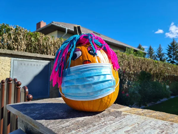 Austria, painted pumpkin with mask, a humorous reference to the covid 19 pandemic