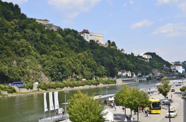 Passau, Almanya - 17 Temmuz 2018: Avusturya sınırına yakın Bavyera 'nın Passau kentindeki Tuna Nehri ve Veste Oberhaus üzerinde tanımlanamayan insanlar, Tuna Nehri, Ilz ve Inn nehirlerinin kesişiminde yer alıyor.