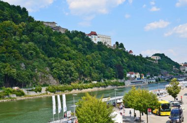 Passau, Almanya - 17 Temmuz 2018: Avusturya sınırına yakın Bavyera 'nın Passau kentindeki Tuna Nehri ve Veste Oberhaus üzerinde tanımlanamayan insanlar, Tuna Nehri, Ilz ve Inn nehirlerinin kesişiminde yer alıyor.