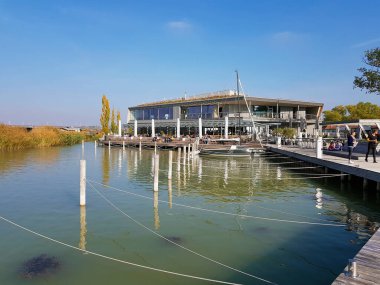 Weiden, Avusturya - 22 Ekim 2019: Kimliği belirsiz insanlar, Burgenland 'da Neusiedlersee adlı bir gölün kıyısındaki güneşli bir sonbahar gününde dinleniyorlar.