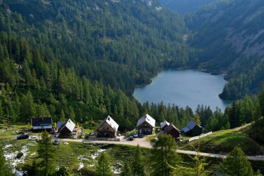 Avusturya, Salzkammergut, Tauplitzalm 'daki Steirersee Gölü' nde kiralık kulübeler, kışın başlangıcından kalma kar kalıntıları.