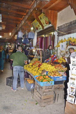 Fez, Fas - 20 Kasım 2014: Medina adlı eski ilçenin çarşısında kimliği belirsiz insanlar ve meyve dükkanı 