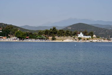 Yunanistan, plajdaki insanlar ve Nea Iraklitsa 'daki Hill' deki otodoks şapeli 