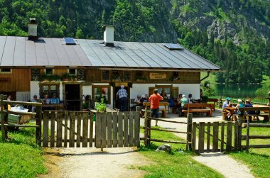 Berchtesgaden, Almanya - 12 Haziran 2015: Koenigssee Gölü 'nde kimliği belirsiz insanlar ve küçük bir han, Bavyera' da tercih edilen turistik bir yer