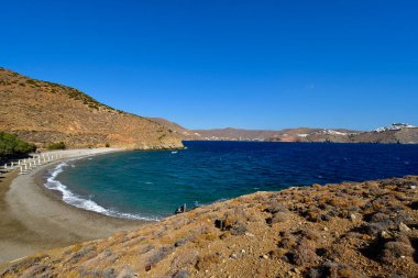 Astypalea, Yunanistan - 4 Eylül 2025: Ege Denizi 'ndeki adada güneşli ve güneşli Agios Konstantinos plajı, Chora Köyü manzaralı