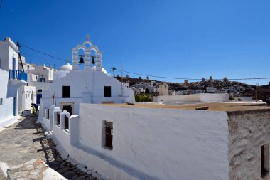 Amorgos, Greece - September 09, 2025: Unknown man playing football with boy in the narrow and winding streets of Chora, a wonderful Cycladic island in the Aegean Sea