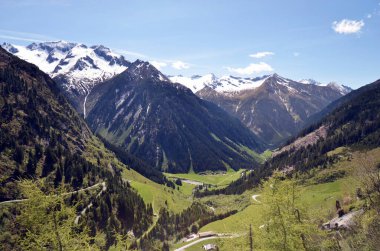 Avusturya, Mayrhofen, Kuzey Tyrol 'daki Zillertal Alpleri' nin kısmen karla kaplı tepelerini ve Stillup Reservoir 'a giden dağ yolunu görüyorsunuz.