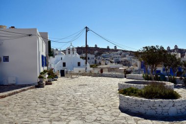 Amorgos, Yunanistan - 11 Eylül 2025: Ege Denizi 'ndeki harika bir Cycladic adası olan Amorgos Adası' ndaki Chora tepesindeki yel değirmenleri, kaldırımlı kare ve beyaz binalar ve All Saints kilisesi