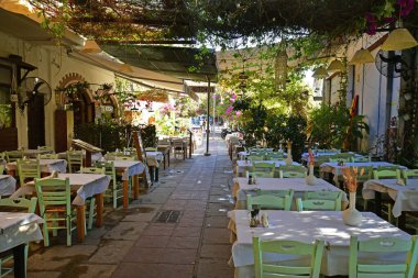 Kos, Greece - September 16, 2025: Passageway in a restaurant with tables and chairs in the outdoor area