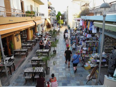 Kos, Greece - September 16, 2025: Unidentified people, shops and restaurants with outdoor seating area in a cobbled street in old town 