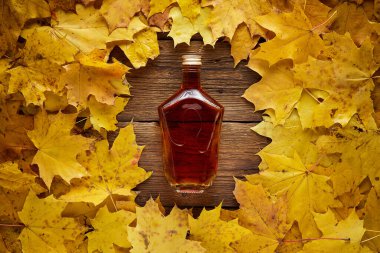 Sarı akçaağaç yapraklı brendi şişesi.