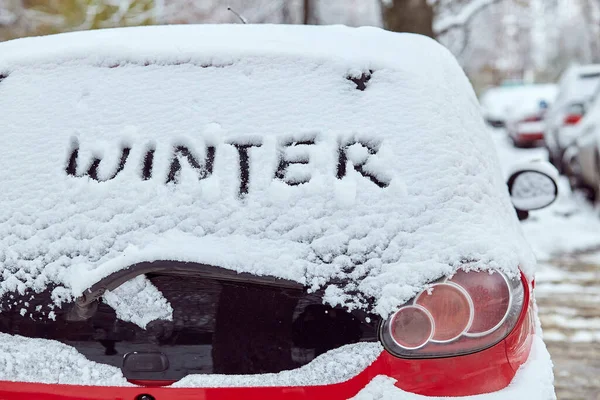 Back window of red car parked on the street in winter day, rear view. Mock-up for sticker or decals