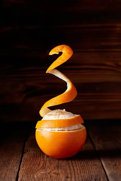 A flying peeled orange on the wooden background — Stock Photo, Image