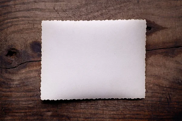 Образец винтажной белой бумаги на фоне деревянного стола. — стоковое фото