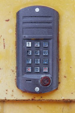 Yuvarlak tuşlu ve metal kapılı karanlık bir dahili telefon..